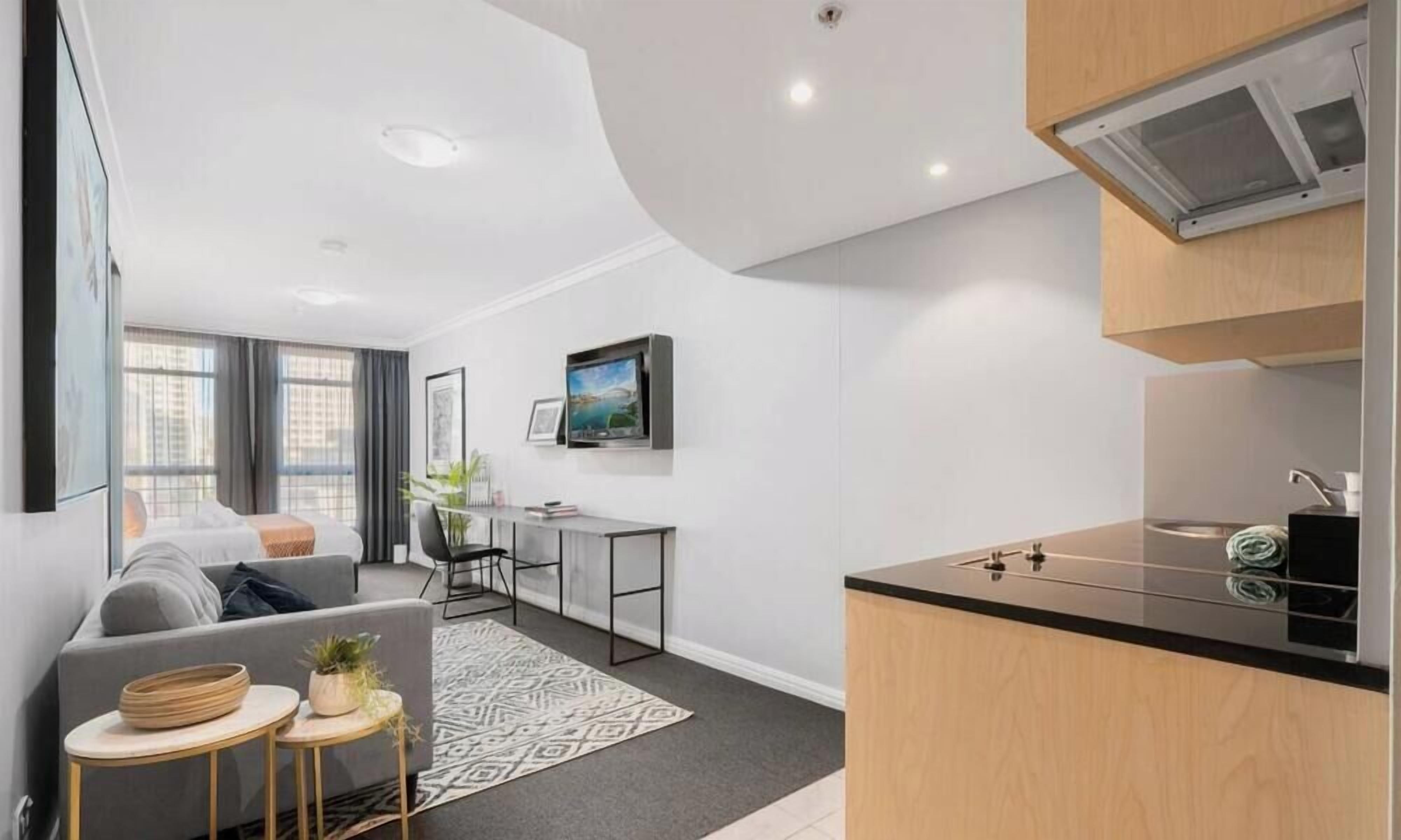 A modern apartment with a living room, dining area, and kitchen.