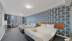 Ein Hotelzimmer mit zwei Betten, einem Schreibtisch und einem Sessel.