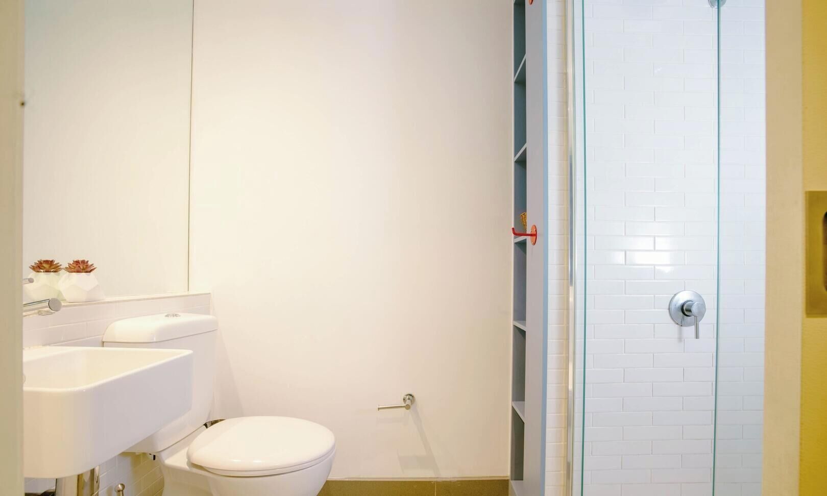 A bathroom with a toilet, sink, and shower.