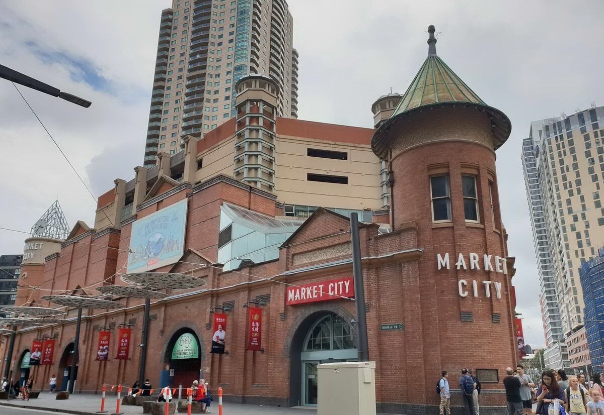 A brick building with a sign reading "MARKET CITY" and a green dome on top.