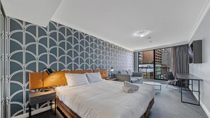 Una habitación de hotel moderna con una cama grande, un escritorio y vistas de la ciudad.