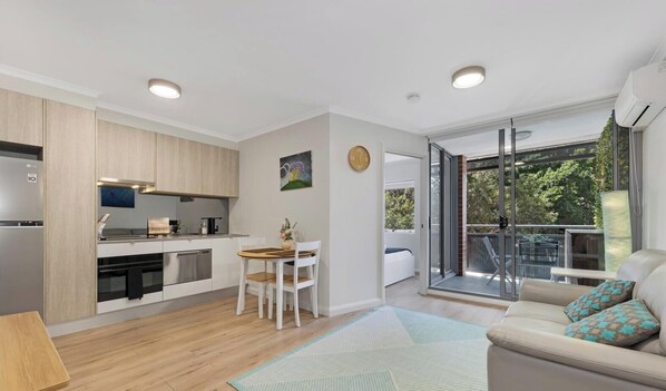 Een modern appartement met keuken, eethoek en balkon met uitzicht.