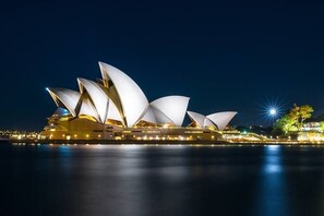 A large, illuminated opera house with multiple tiered, white, sail-like structures. - KozyGuru | Ryde | Cosy 2Bed Apt with Private Yard (Ryde)