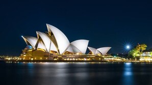 A large, illuminated opera house with multiple tiered, white, sail-like structures. - KozyGuru | Haymarket | Best Location Studio (Haymarket)