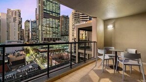 Ein Balkon mit Blick auf die Stadt, ein kleiner Tisch und zwei Stühle.