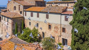 Un edificio histórico de piedra con múltiples ventanas y techo de tejas.