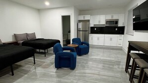 Een modern appartement met een zithoek, keuken en een eetgedeelte.