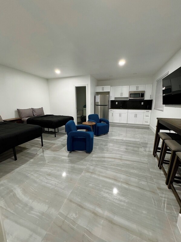 A modern apartment with a living area, kitchen, and a dining space.