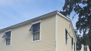 A two-story house with a garage, a brick foundation, and a staircase leading to a porch. - Charming, 1-bdrm apt, visit the Marshwalk, Huntington St Pk & Brookgreen Gardens (Murrells Inlet)