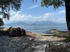 Una costa rocosa con vista al mar y montañas lejanas.