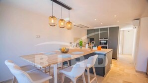 A modern kitchen with a central island, bar stools, pendant lighting, and a view into the adjacent living area. - GASSIN BEAUTIFUL VILLA WITH SWIMMING POOL (GASSIN)