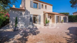 A two-story house with a tiled roof, a gravel driveway, and potted plants. - GASSIN BEAUTIFUL VILLA WITH SWIMMING POOL (GASSIN)