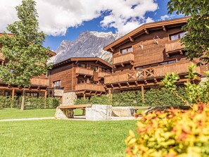 Eine Holzhütte mit Balkonen vor einer Bergkulisse.
