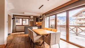 Une cuisine moderne dotée d’un grand îlot central, de planchers en bois et d’un coin repas avec une table et des chaises.
