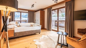 A modern bedroom with a large bed, a desk, a chair, and a TV. - Penthouse mit 3 Schlafzimmern by Interhome (Ehrwald)