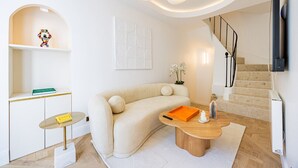 Uma sala de estar moderna com um sofá, mesa de centro e escada.
