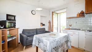 Una cocina compacta con una mesa de comedor, un sofá y un microondas.