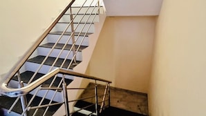 A staircase with metal railings and a black carpeted floor. - Hotel Grand Imperial (Chhatrapati Sambhajinagar)
