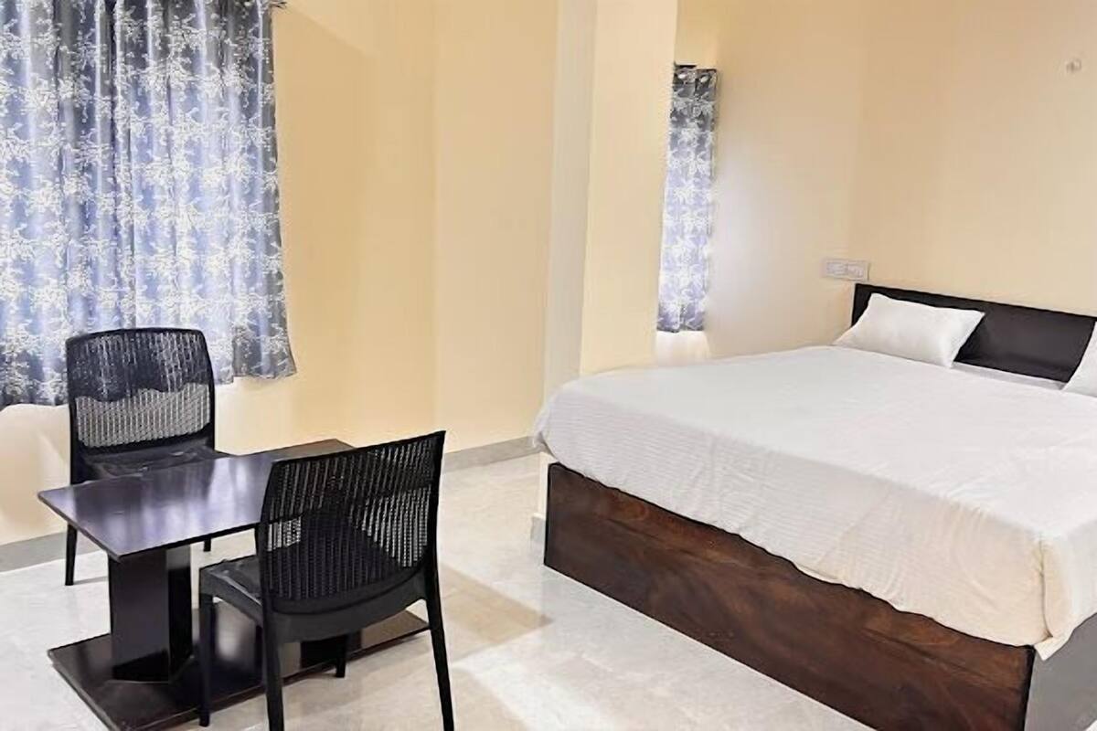 Une chambre d’hôtel avec un lit, un bureau et une chaise.