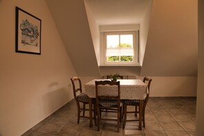 Enjoy meals in this cozy dining area with a table for four, surrounded by comfortable chairs and a beautiful piece of artwork.