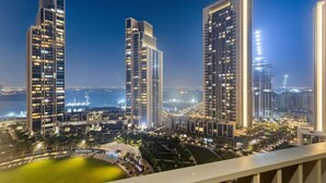 Un ensemble immobilier composé d’immeubles de grande hauteur, avec de nombreuses tours, des fenêtres illuminées et une zone environnante bien éclairée.