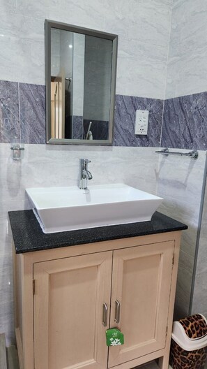 A bathroom with a white sink, a mirror above it, and a towel rack.