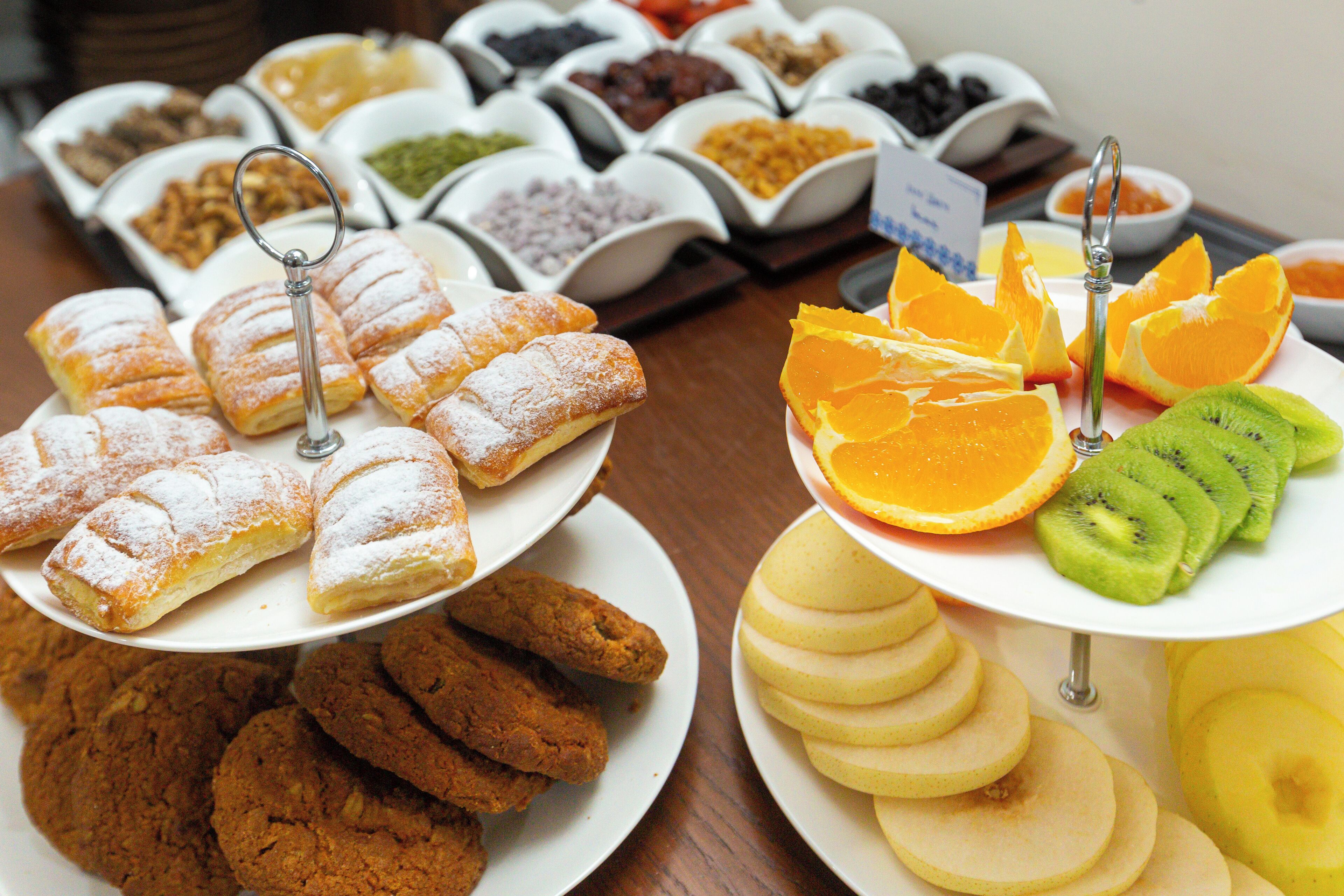 A buffet with various food items including pastries, fruits, and other snacks.