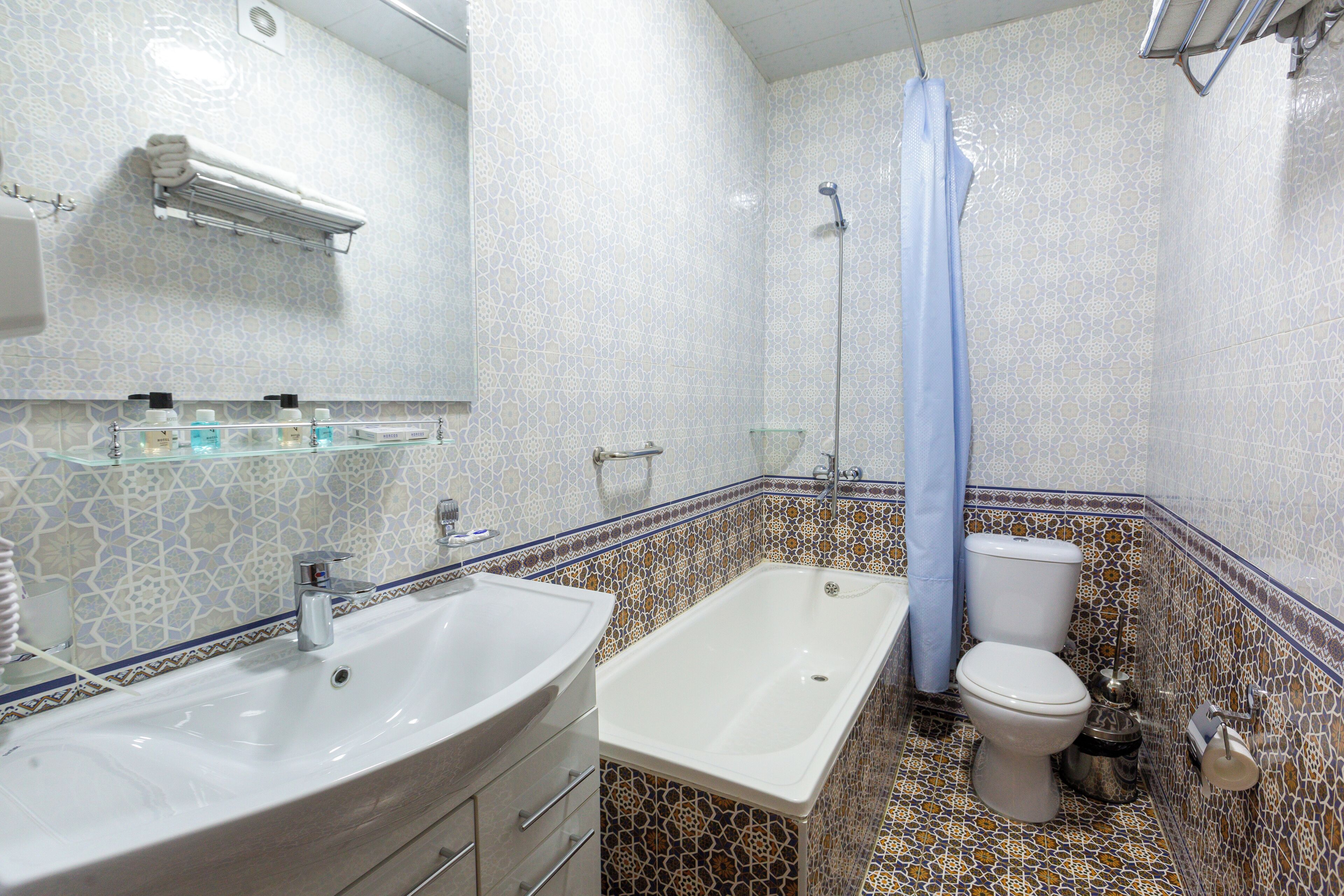 A bathroom with a sink, bathtub, toilet, and shower curtain.