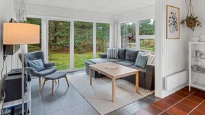 Un salon moderne avec un canapé gris, une table basse en bois et un meuble pour la télévision.
