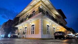 A multi-story building with a prominent corner balcony, large windows, and a paved entrance area. - Room deluxe with communal pool Ma4 (Ciudad de Panamá)