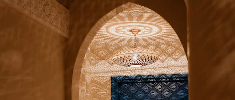 An arched doorway with intricate patterns and a blue door.