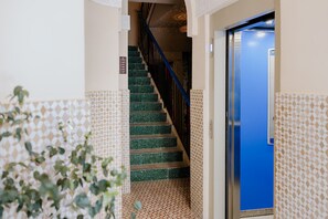 A staircase with green tiles leading to a blue door, surrounded by patterned walls. - Room Superior with communal pool Ma11 (Ciudad de Panamá)