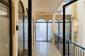 A corridor with a tiled floor, a glass door with a number, and a balcony with a railing. - Single Room Duplex and communal pool Ma9 (Ciudad de Panamá)