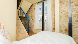 Ein Schlafzimmer mit einem Bett, einer Treppe und einer Steinsäule.