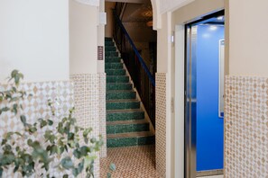 A staircase with green tiles leading to a blue door, surrounded by patterned walls. - Single Room Duplex and communal pool Ma9 (Ciudad de Panamá)