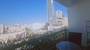 A balcony with a view of a cityscape, including modern buildings and a clear sky. - STAY Limdream Apartment (Limassol)