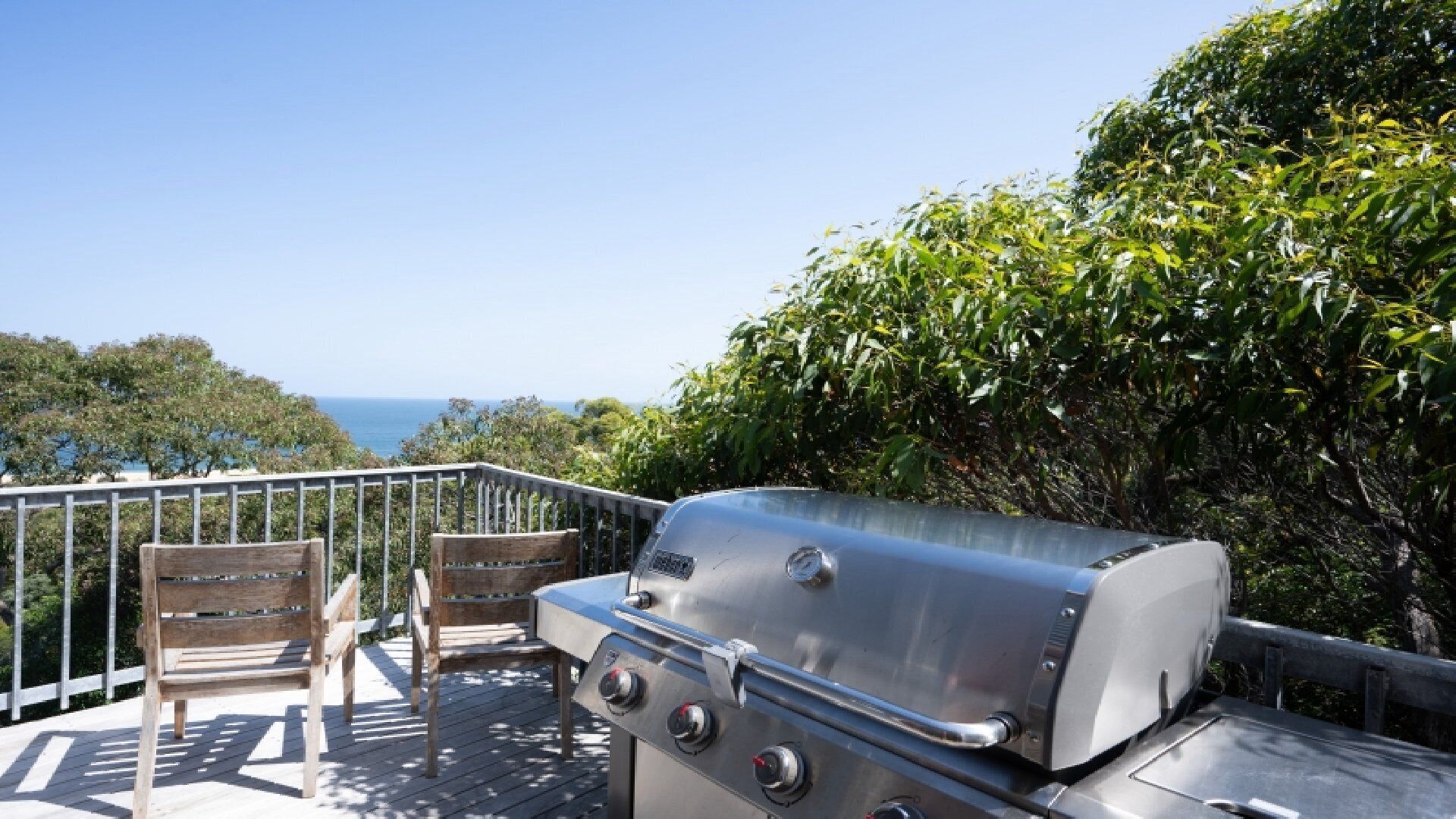 Een barbecue op een terras met uitzicht op de oceaan.
