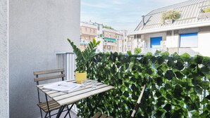 A balcony with a table, chair, and potted plant. - Easylife - Apartment with balcony near Navigli (Milano)