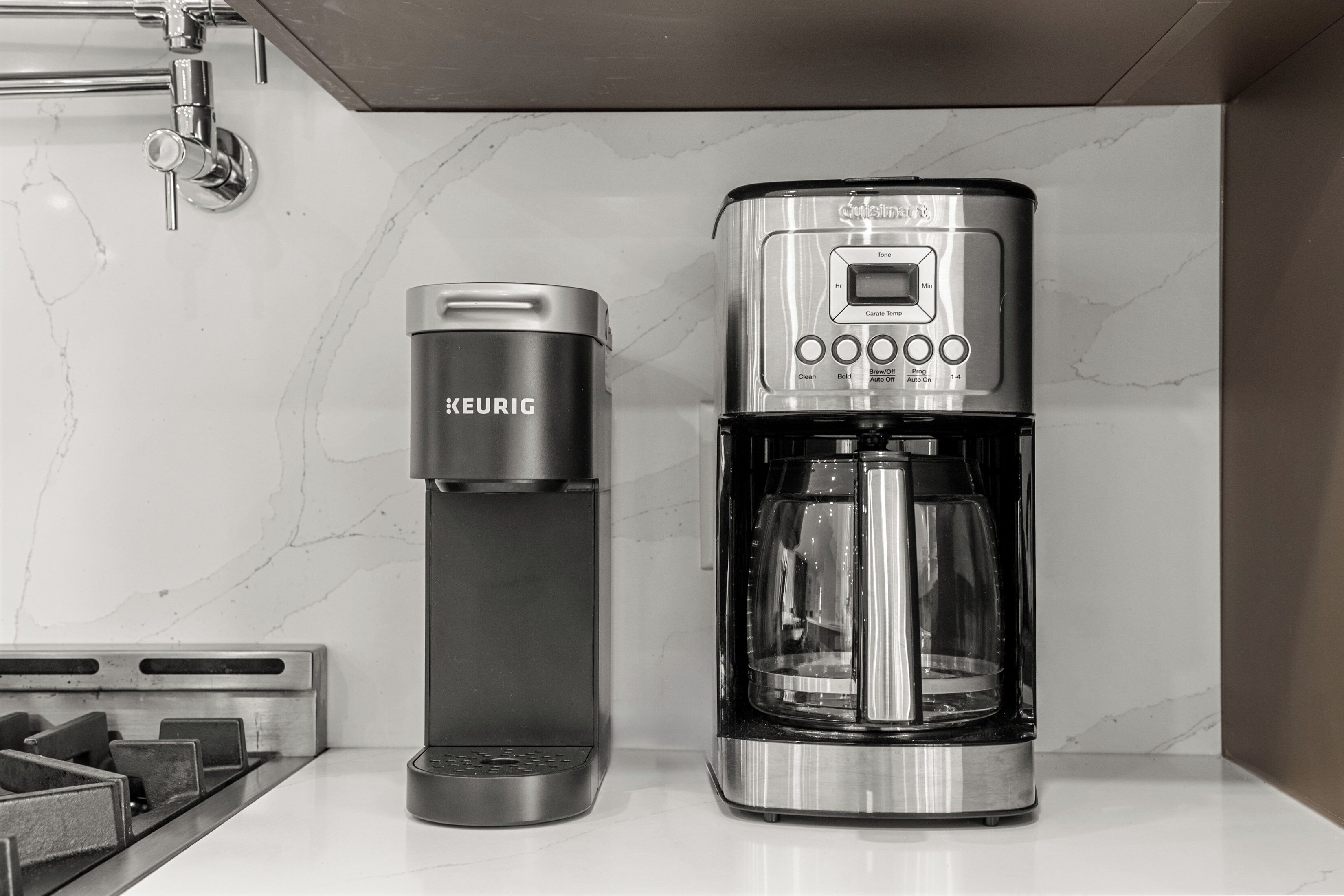 A kitchen with a Keurig coffee maker and a coffee pot.