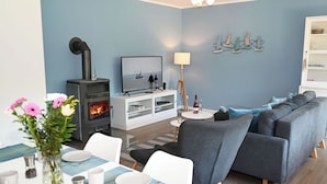 A modern living room with a fireplace, a TV, and a sofa.