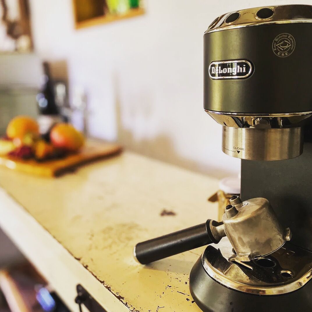 Una cafetera espresso DeLonghi sobre una encimera de cocina.