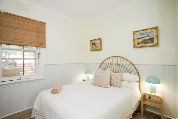 Relax in a cozy bedroom with soft light and artwork.