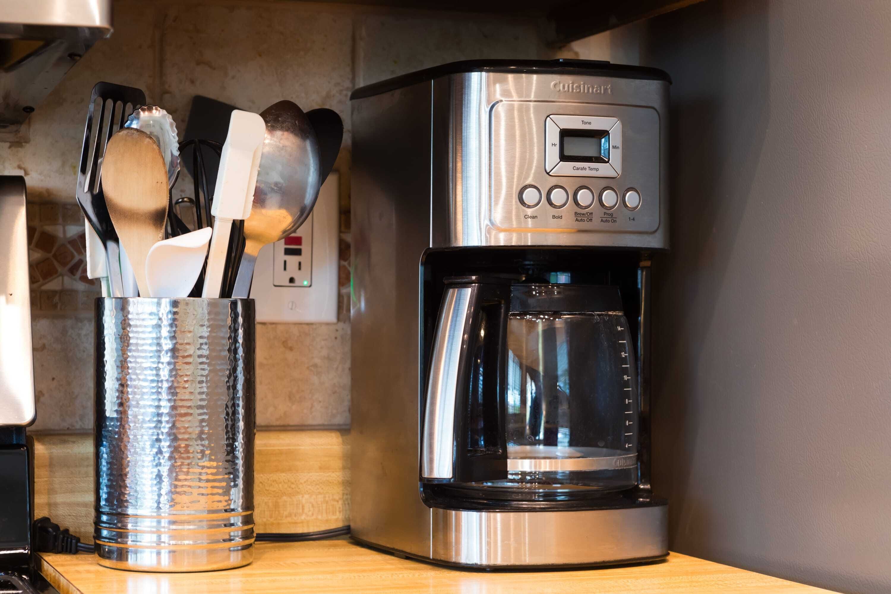 A kitchen with a coffee maker and a utensil holder.