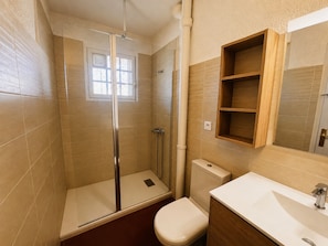 A bathroom with a shower, toilet, and sink.