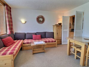 A cozy room with a sofa, a wooden table, and a cabinet.