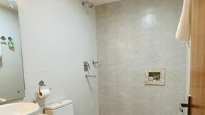 Een badkamer met een groot wastafel, toilet en douche.