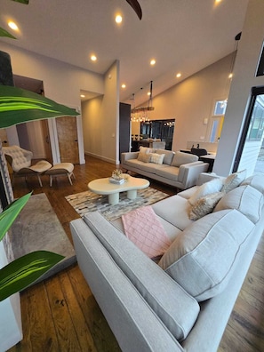 A modern living room with a sofa, a coffee table, and a dining area. - Modern Midcentury Bohemian Style gem-uptown (Charlotte)