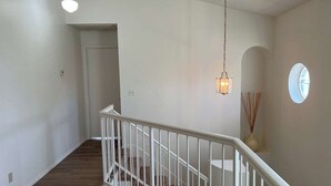 Eine Treppe mit weißer Handläufung, die zu einer Zwischenebene führt.