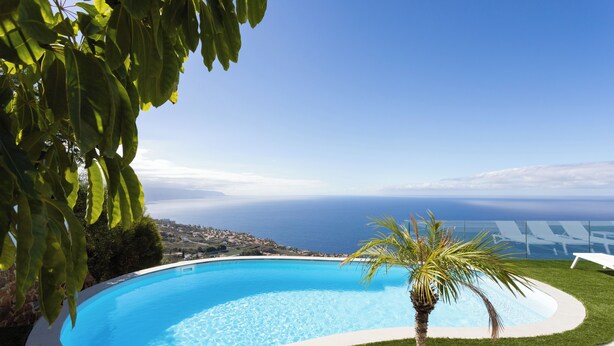 A swimming pool with a clear view of the ocean and a distant town. - VILLA CANELA, VACATION HOME IN THE NORTH OF TENERIFE (El Sauzal)