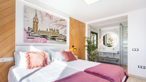 A modern hotel room with a large bed, a wall-mounted mirror, and a view of the cityscape. - VILLA CANELA, VACATION HOME IN THE NORTH OF TENERIFE (El Sauzal)